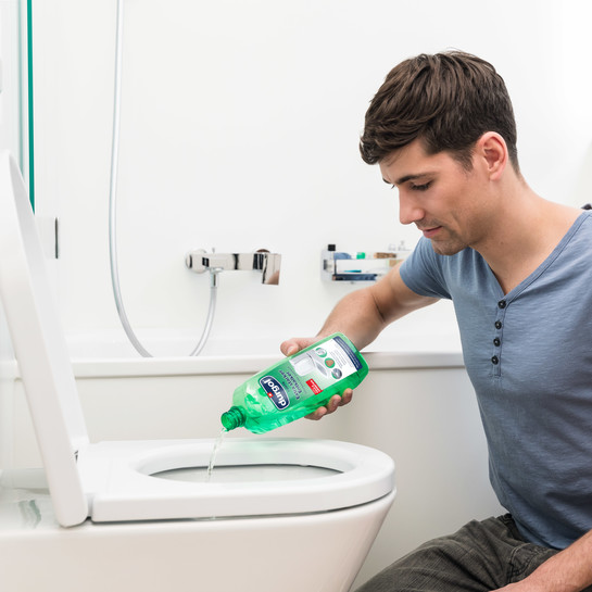 Homme qui applique le detartrant puissant Durgol Forte dans une cuvette de WC