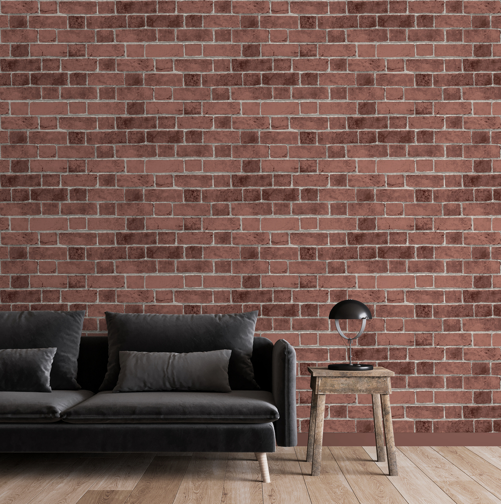 Canapé noir devant un papier peint expansé motif briques rouges relief