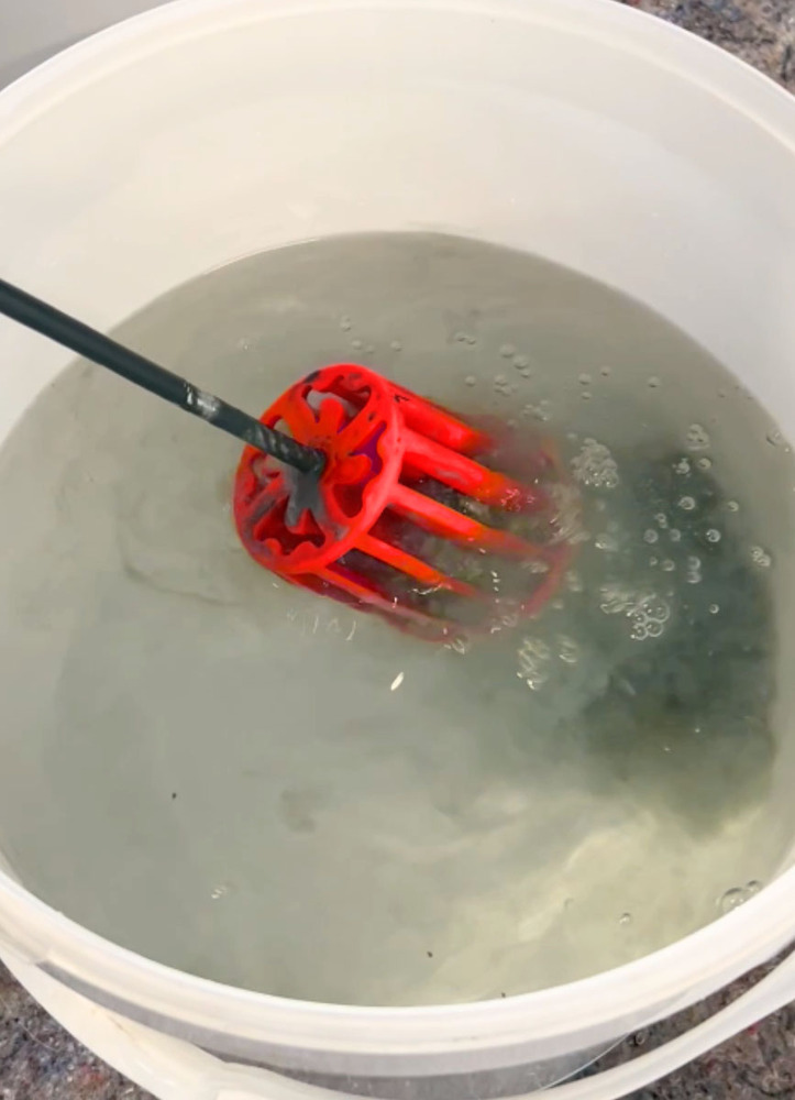 Nettoyeur de rouleau de peinture dans un seau d'eau