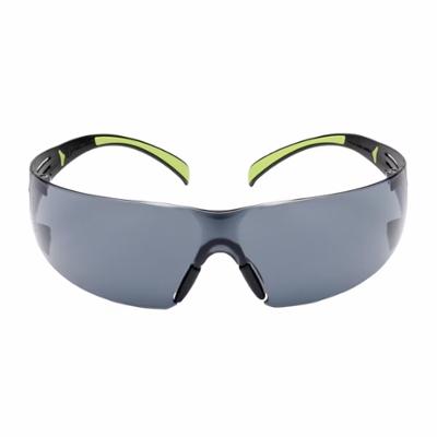 Lunettes de protection à verres teintés gris avec monture noire et branches intérieures vert fluo.